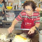 woman preparing okonomiyaki - Hiroshima style